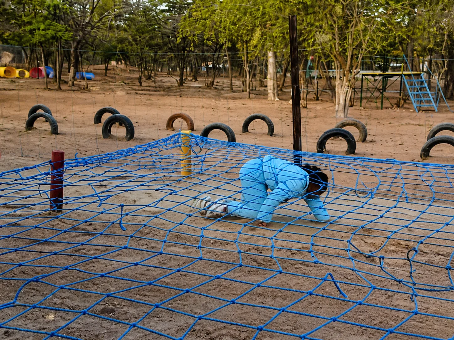 Child completing the rope-net obstacle course at Stone Creek Farm